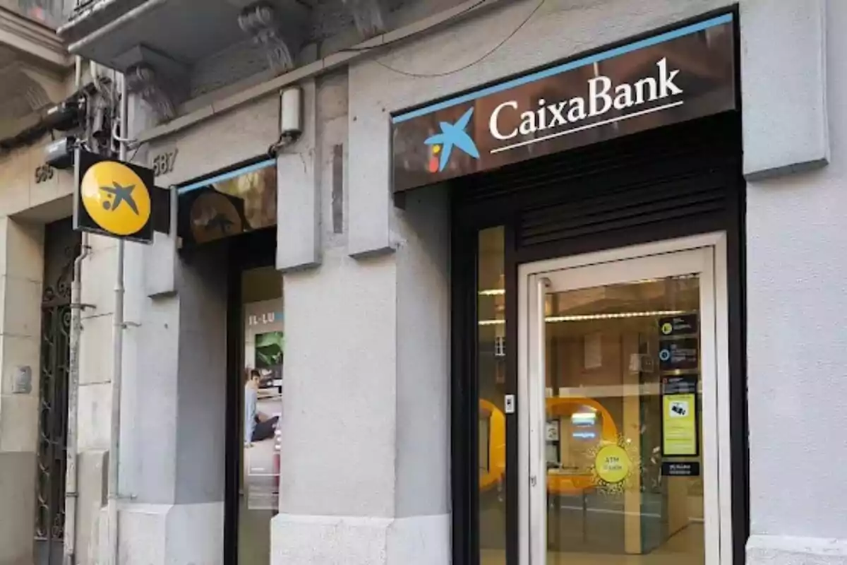 Fachada de una sucursal de CaixaBank con su logotipo visible en la entrada.