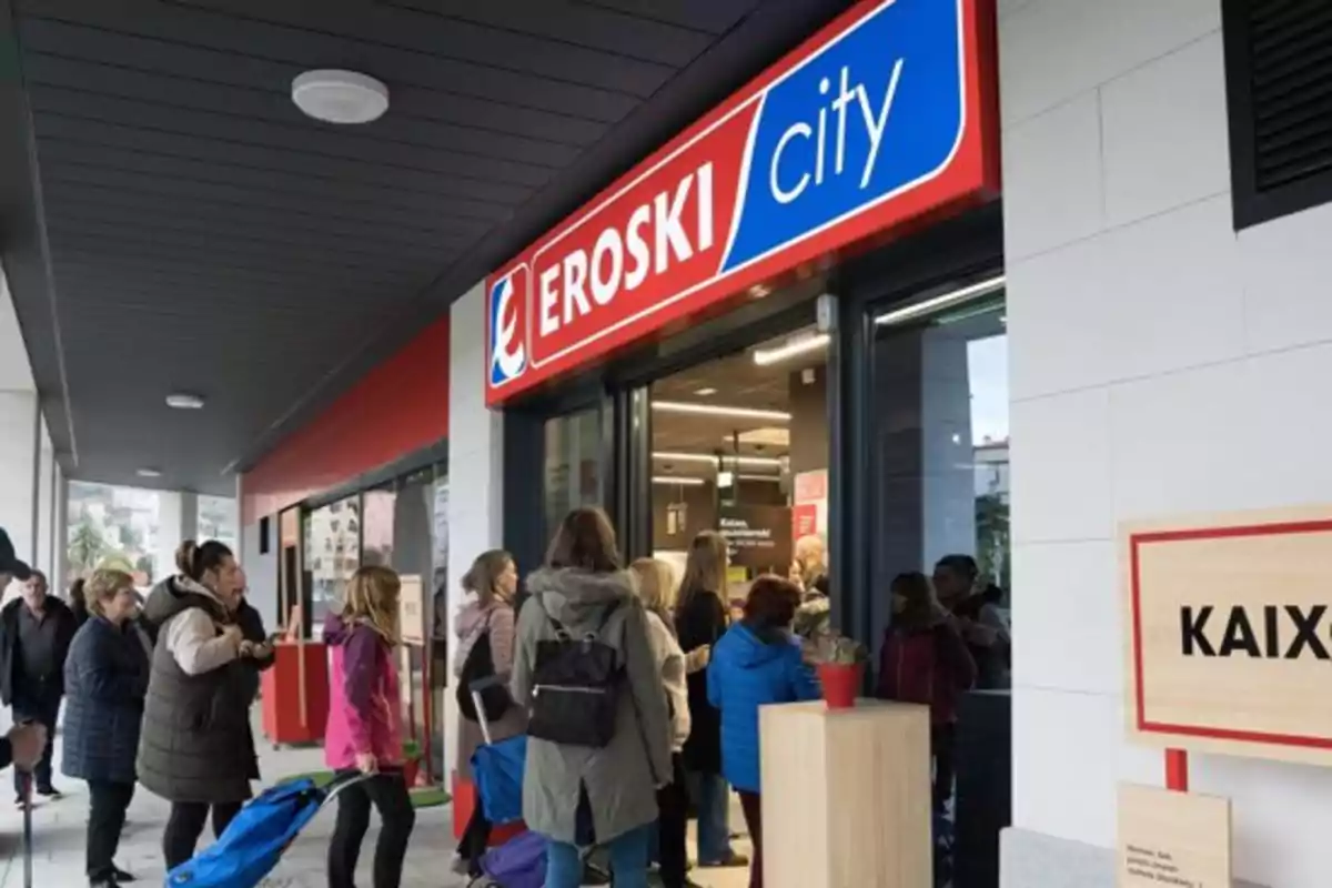 Personas haciendo fila para entrar a un supermercado Eroski City.