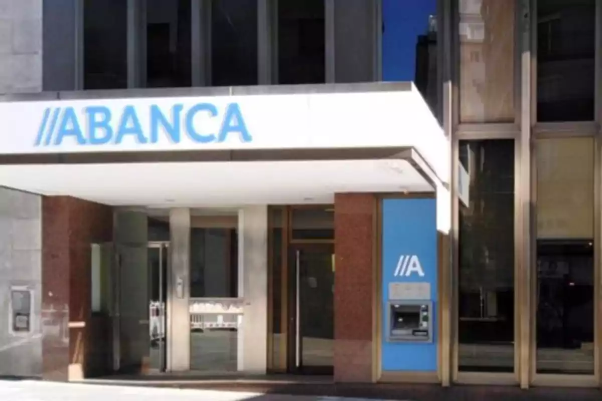 Entrada de una sucursal bancaria de ABANCA con un cajero automático en la fachada.