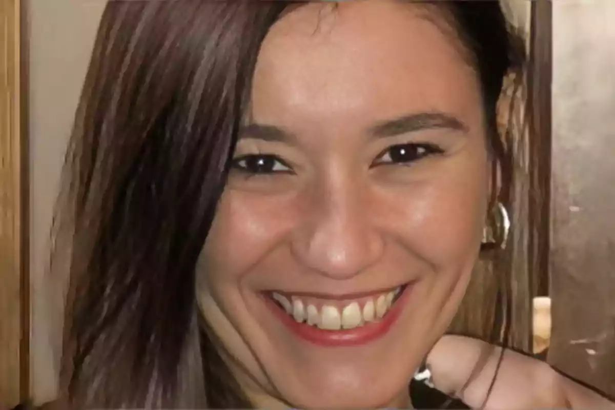 Una persona sonriendo frente a la cámara.