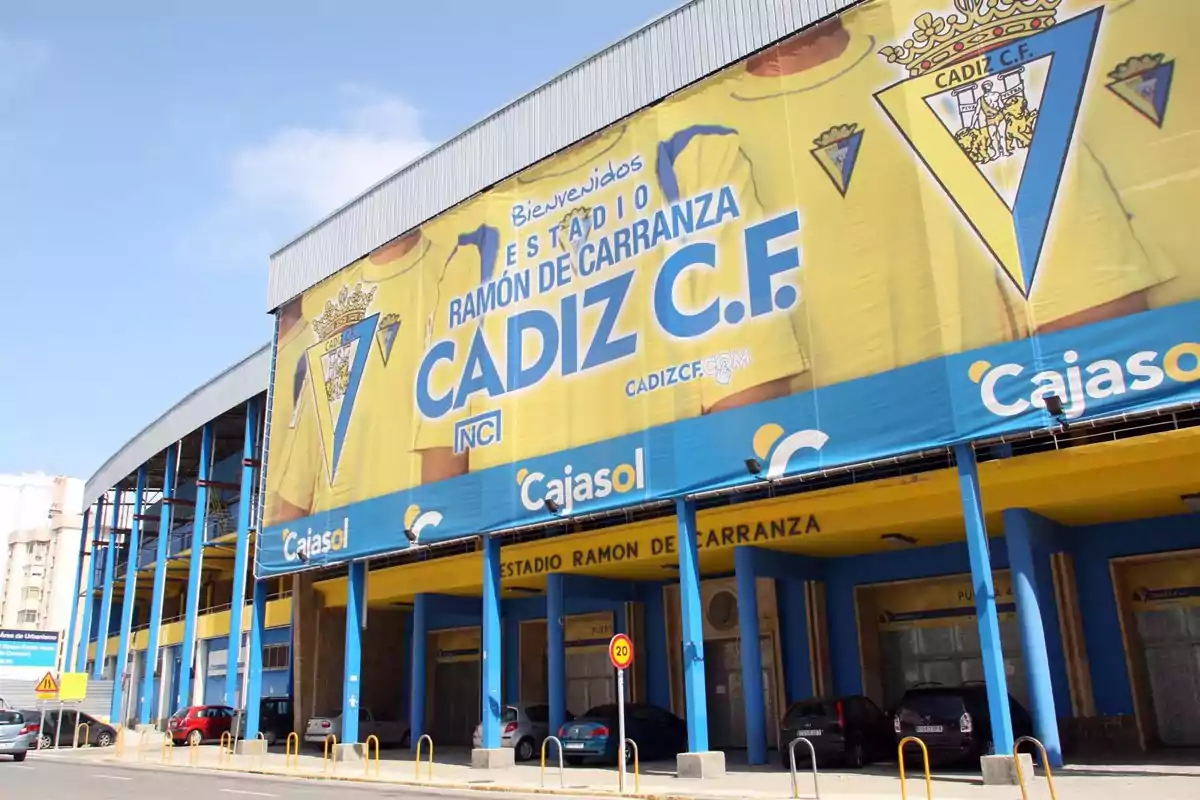 Fachada del Estadio Ramón de Carranza del Cádiz C.F. con un gran cartel amarillo y azul.