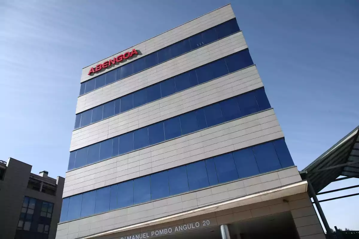 Edificio de oficinas de Abengoa con fachada de vidrio y cielo despejado.