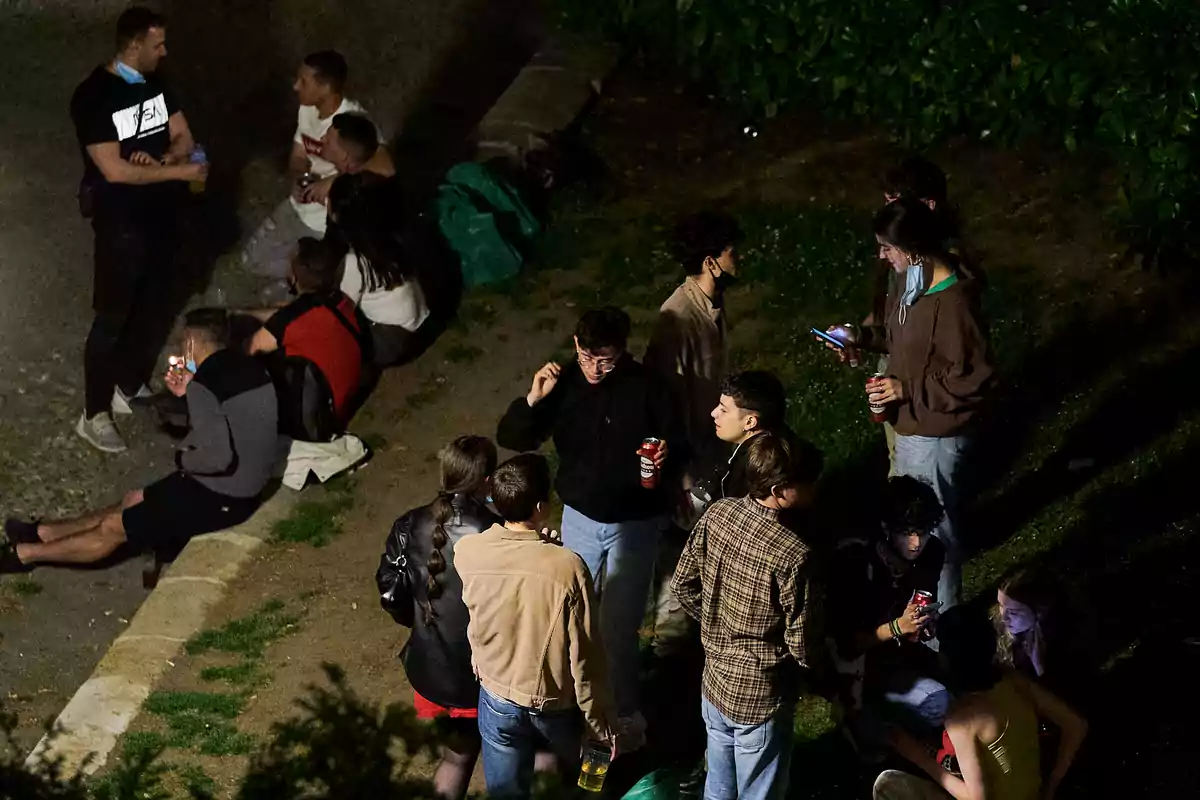 Un grupo de personas socializando al aire libre durante la noche.