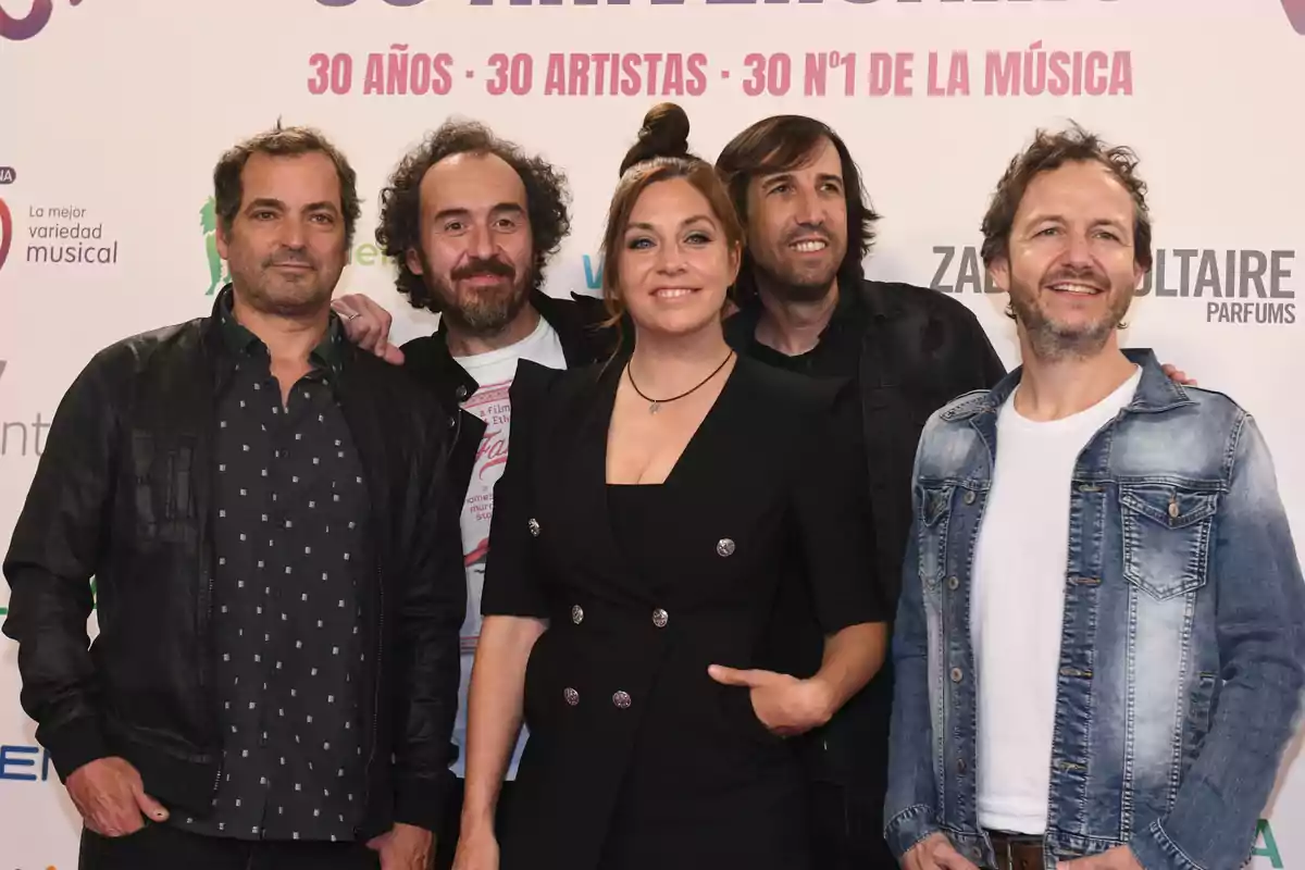 Un grupo de personas posando juntas en un evento de celebración de 30 años de música.