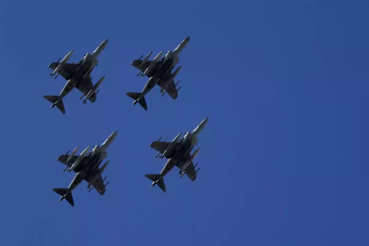 Cuatro aviones militares vuelan en formación sobre un cielo despejado.