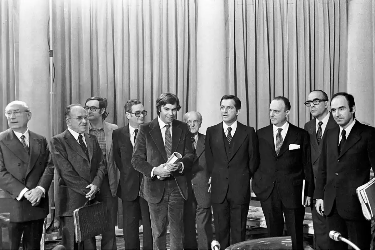 Un grupo de hombres en traje posando juntos frente a una cortina.