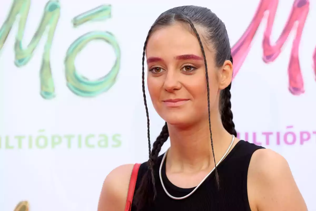 Una joven con trenzas y maquillaje colorido en un evento de Multiópticas.