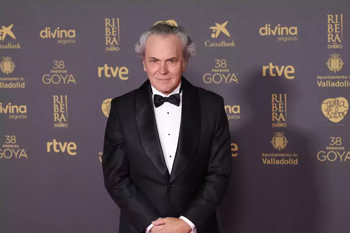 Hombre con esmoquin negro y pajarita en la alfombra roja de los Premios Goya.