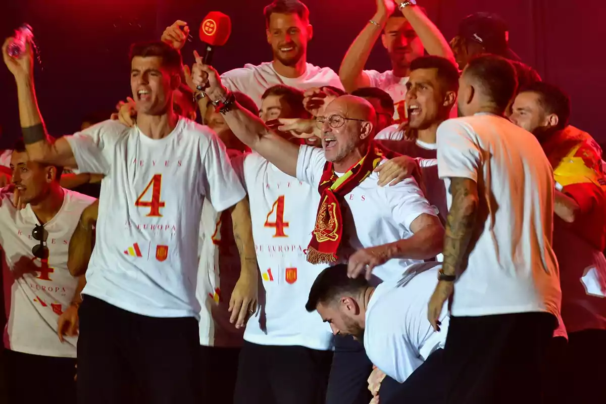 Un grupo de personas celebrando con camisetas blancas que tienen el número 4 y la palabra 