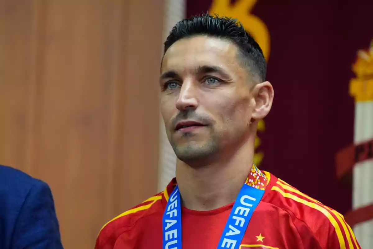 Un hombre con una medalla de la UEFA vistiendo una camiseta roja.