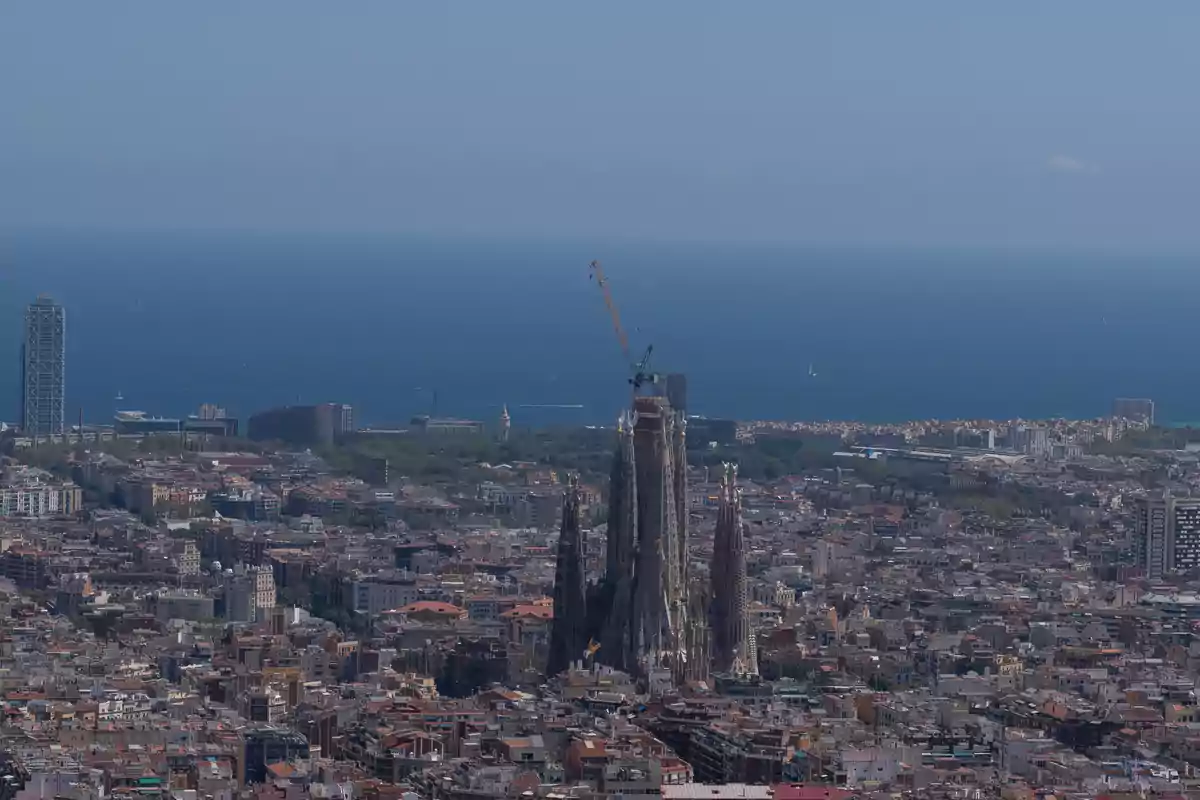 Vista panorámica de la ciudad de Barcelona con la Sagrada Familia en el centro y el mar Mediterráneo al fondo Vista panorámica de la ciudad de Barcelona con la Sagrada Familia en el centro y el mar Mediterráneo al fondo