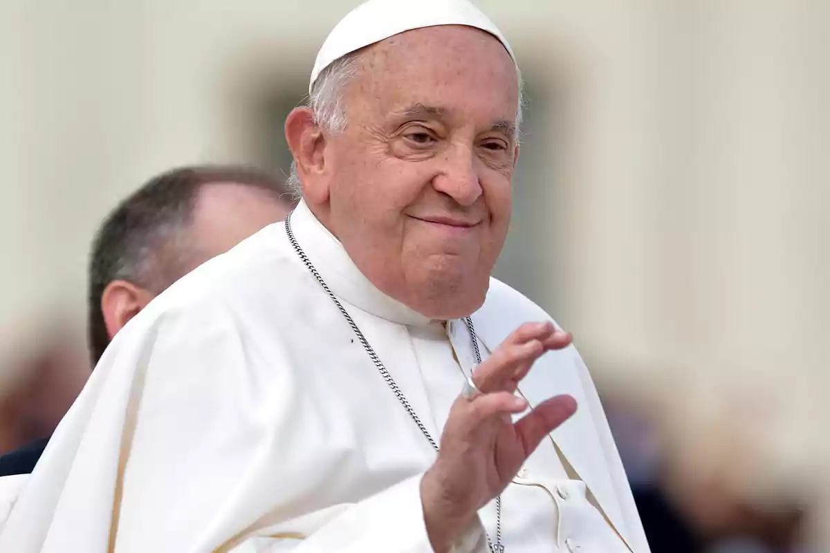 Una persona vestida con atuendo religioso blanco haciendo un gesto con la mano.