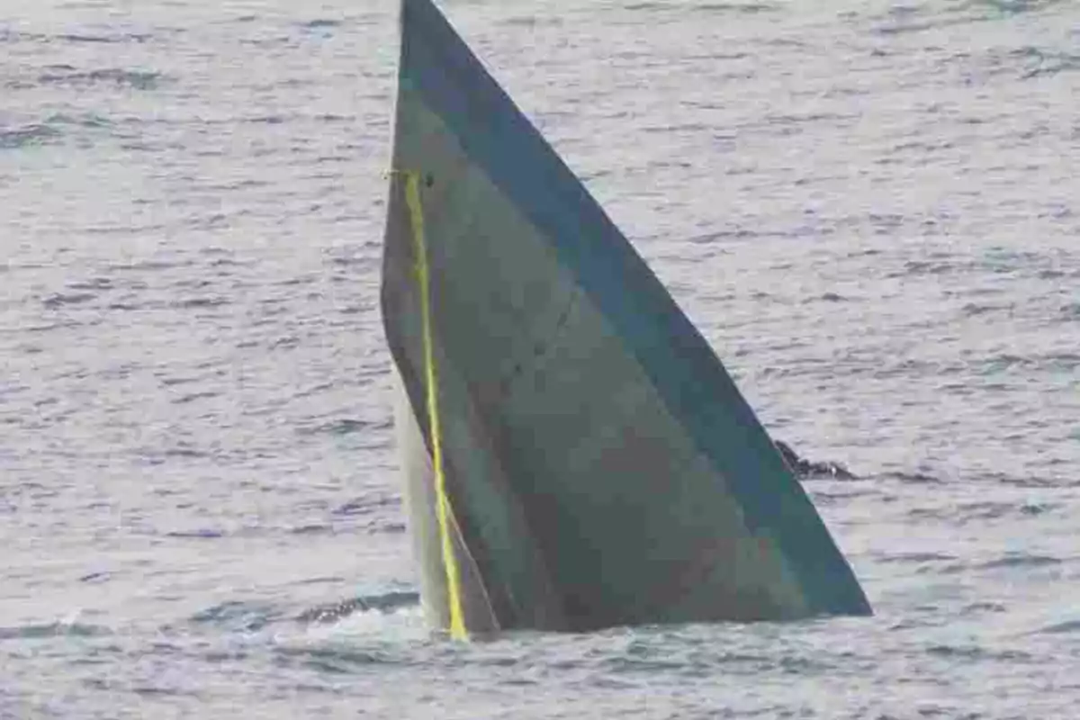 Un barco parcialmente sumergido en el agua con solo la proa visible.