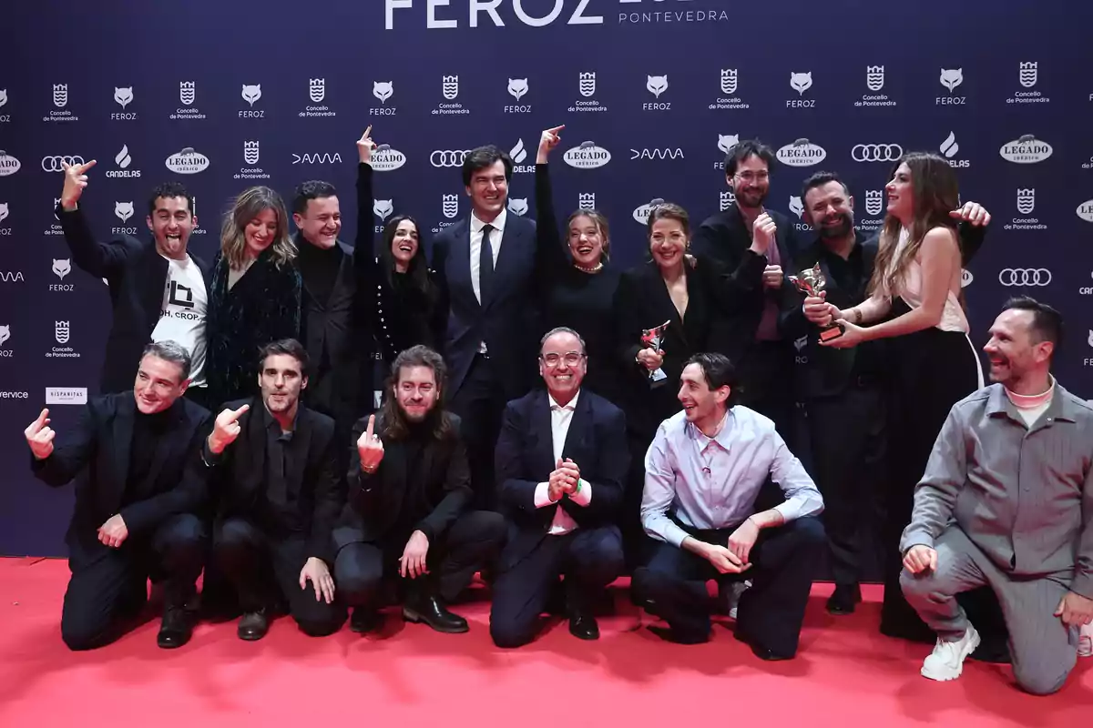 Un grupo de personas posando en una alfombra roja durante un evento de premios.