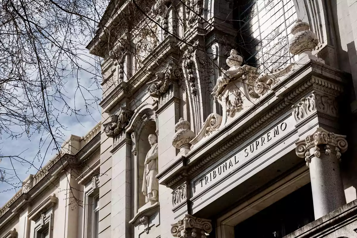 Fachada del Tribunal Supremo de España con detalles arquitectónicos ornamentados y una estatua en la entrada principal Fachada del Tribunal Supremo de España con detalles arquitectónicos ornamentados y una estatua en la entrada principal