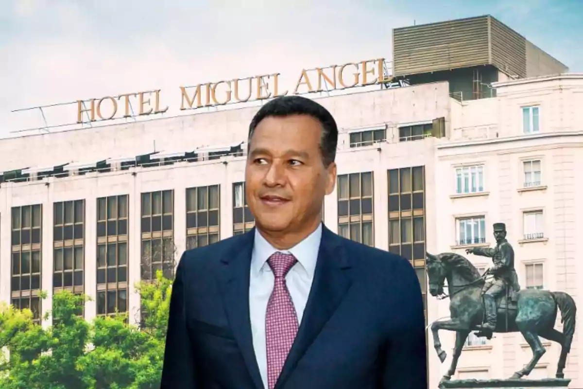 Un hombre con traje y corbata frente al Hotel Miguel Ángel y una estatua ecuestre.