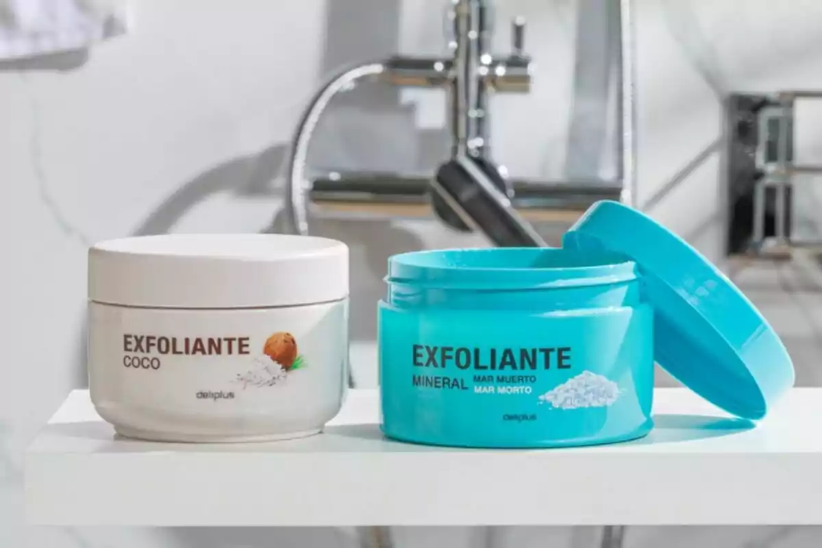 Dos envases de exfoliantes Deliplus, uno de coco y otro mineral, sobre una superficie blanca con un grifo de fondo. Dos envases de exfoliantes Deliplus, uno de coco y otro mineral, sobre una superficie blanca con un grifo de fondo.