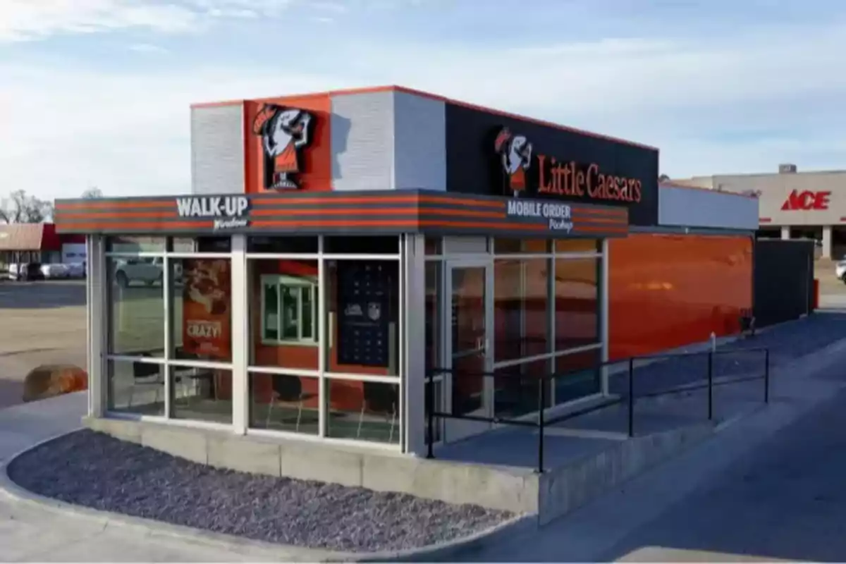 Una pequeña sucursal de Little Caesars con ventanilla para pedidos a pie y recogida de pedidos móviles. Una pequeña sucursal de Little Caesars con ventanilla para pedidos a pie y recogida de pedidos móviles.