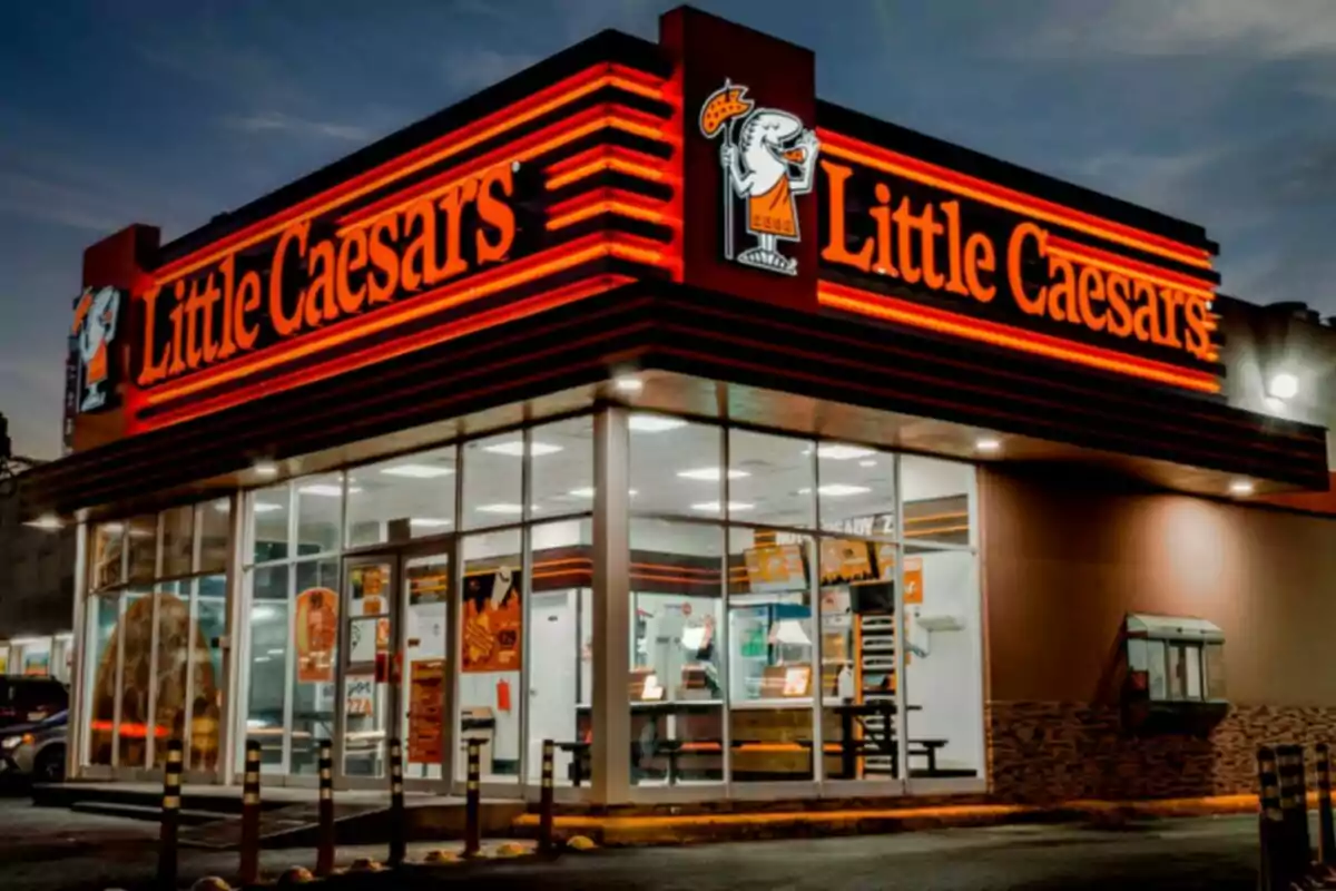 A Little Caesars chain pizzeria lit up at night. A Little Caesars chain pizzeria lit up at night.