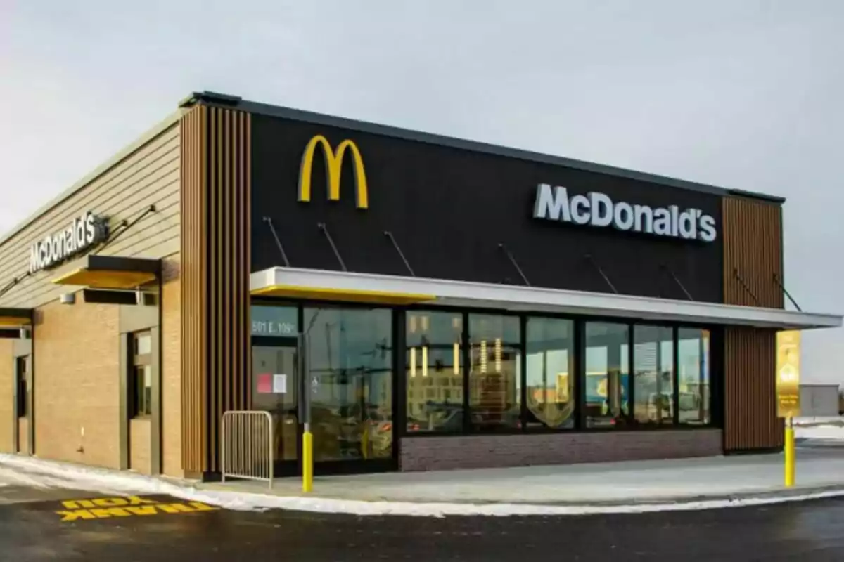 Un restaurante de comida rápida con un diseño moderno y un logotipo amarillo en la fachada. Un restaurante de comida rápida con un diseño moderno y un logotipo amarillo en la fachada.