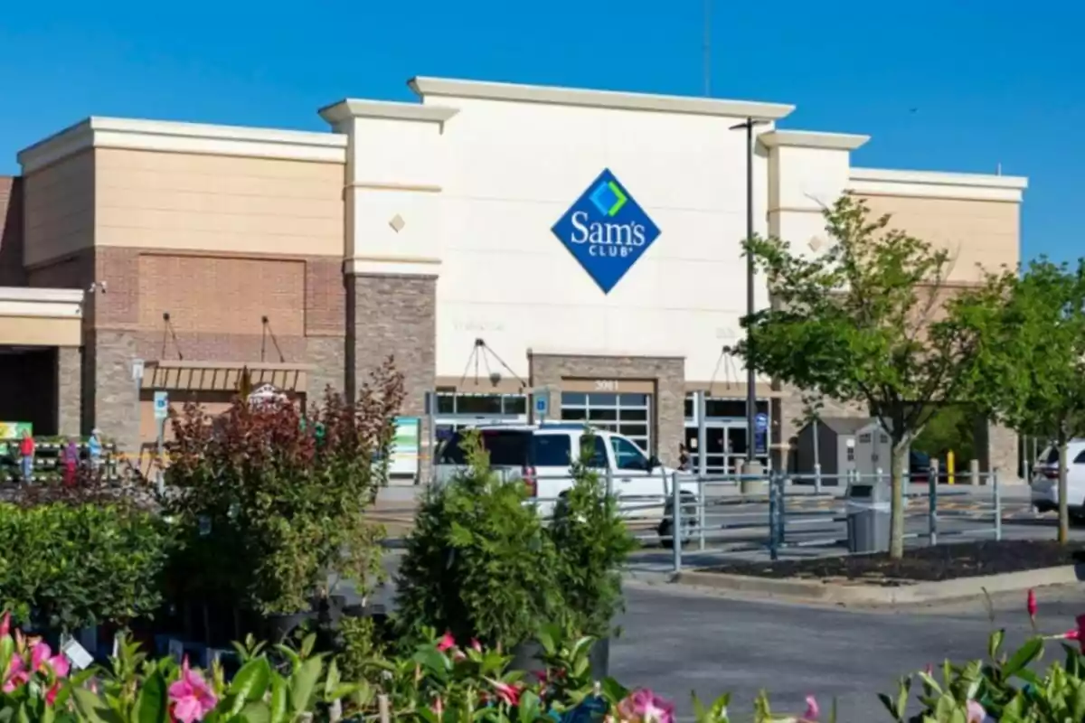 Fachada de una tienda Sam's Club con un estacionamiento al frente y vegetación en primer plano. Fachada de una tienda Sam's Club con un estacionamiento al frente y vegetación en primer plano.