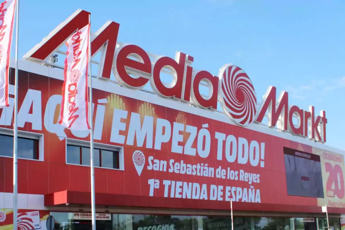 Fachada de una tienda MediaMarkt con un cartel que dice "AQUÍ EMPEZÓ TODO! San Sebastián de los Reyes 1ª TIENDA DE ESPAÑA".