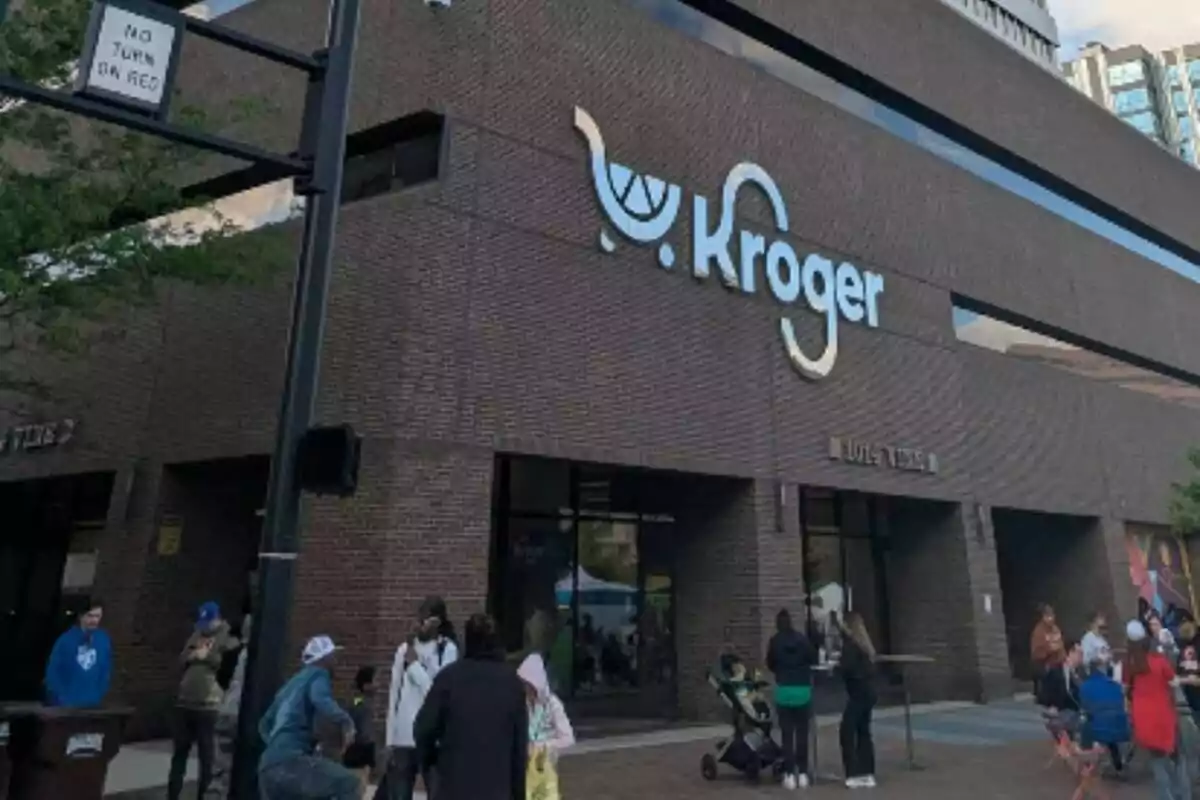 Fachada de una tienda Kroger con varias personas reunidas en la entrada. Fachada de una tienda Kroger con varias personas reunidas en la entrada.