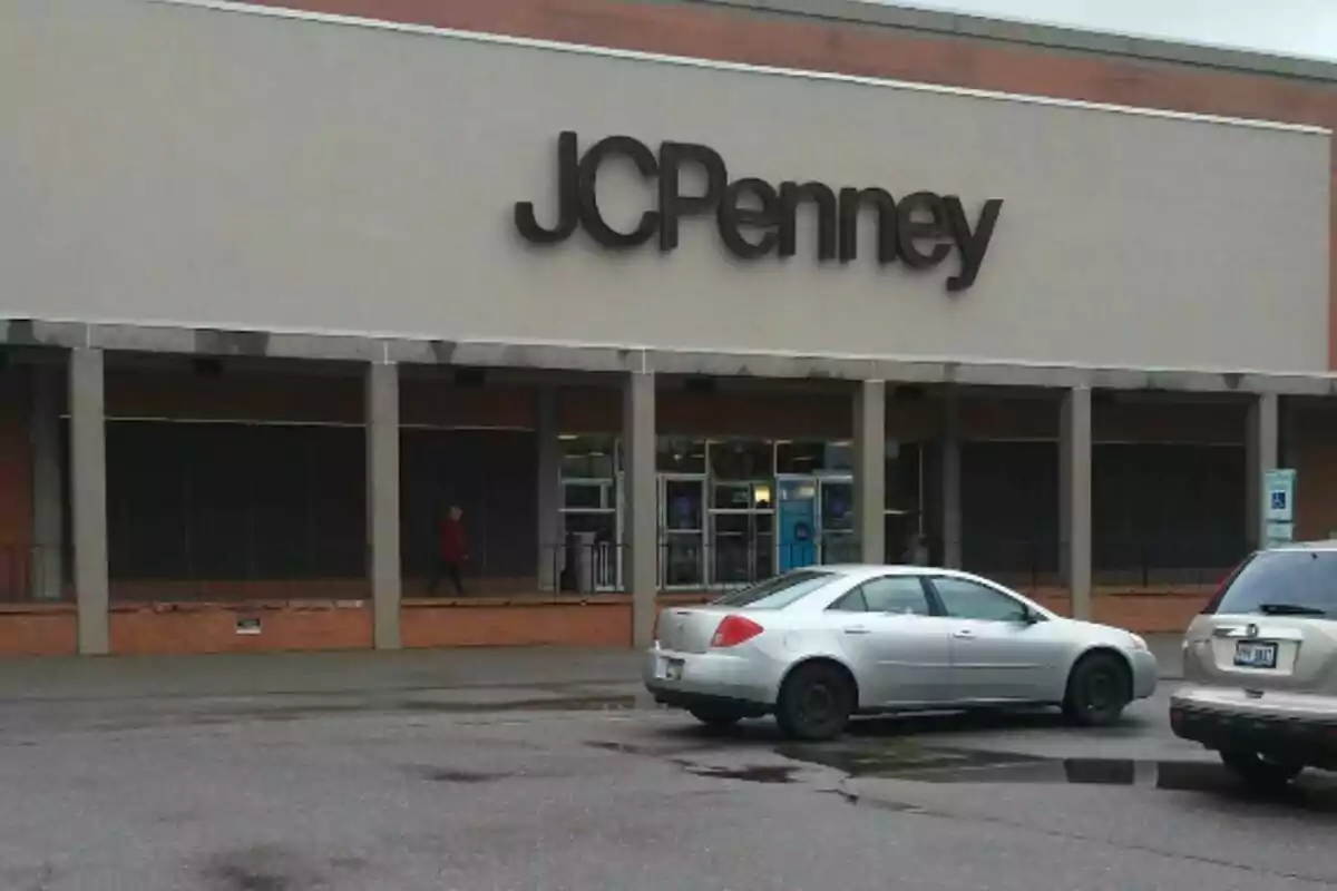 Fachada de una tienda JCPenney con un automóvil plateado estacionado al frente en un día nublado. Fachada de una tienda JCPenney con un automóvil plateado estacionado al frente en un día nublado.