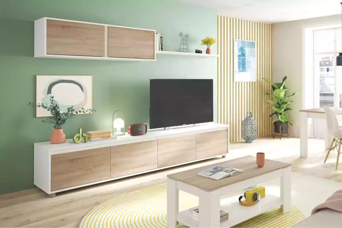 Una sala de estar moderna con paredes verdes, muebles de madera clara y detalles decorativos como plantas y cuadros, creando un ambiente acogedor y luminoso.