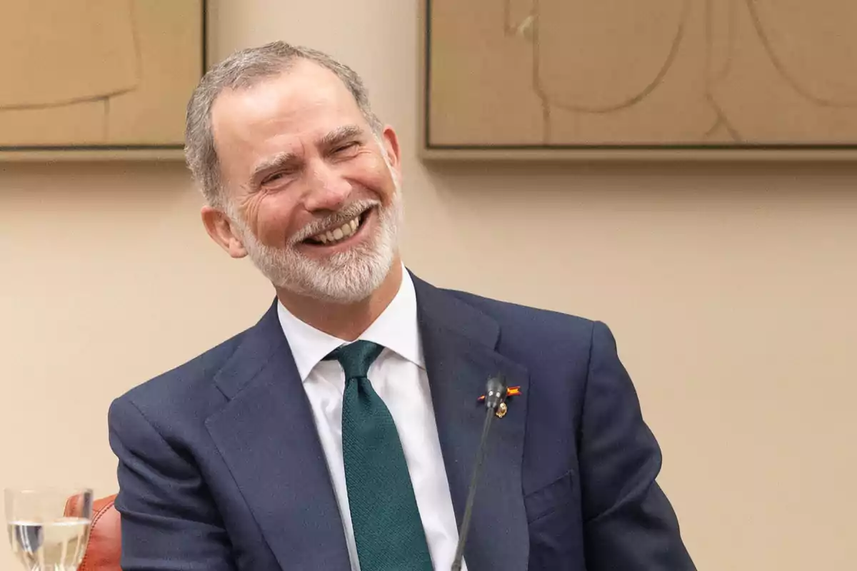 Felipe VI traje sonríe mientras está sentado en una sala. Felipe VI traje sonríe mientras está sentado en una sala.
