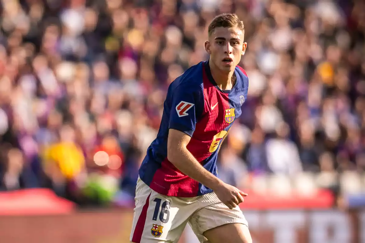 Jugador del FC Barcelona con el uniforme azul y grana en un partido de fútbol con el público desenfocado al fondo Jugador del FC Barcelona con el uniforme azul y grana en un partido de fútbol con el público desenfocado al fondo