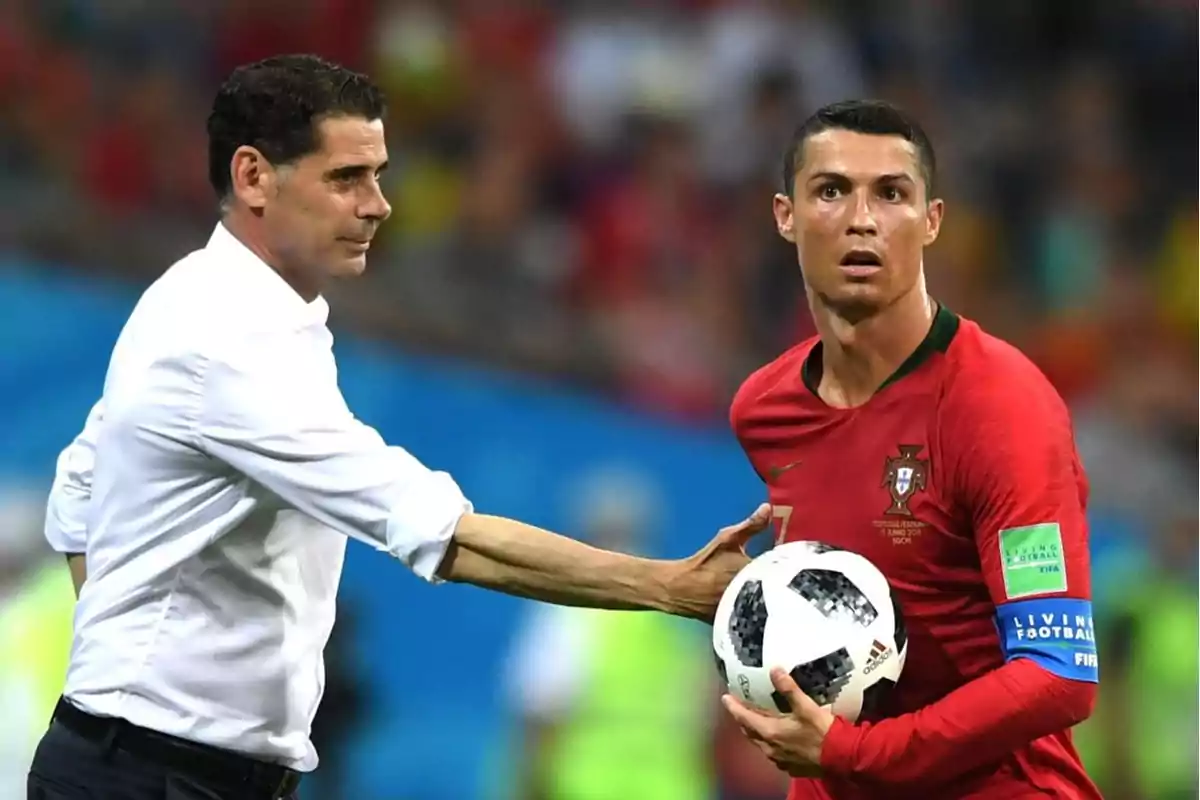 Un entrenador de fútbol da instrucciones a un jugador que sostiene un balón durante un partido.