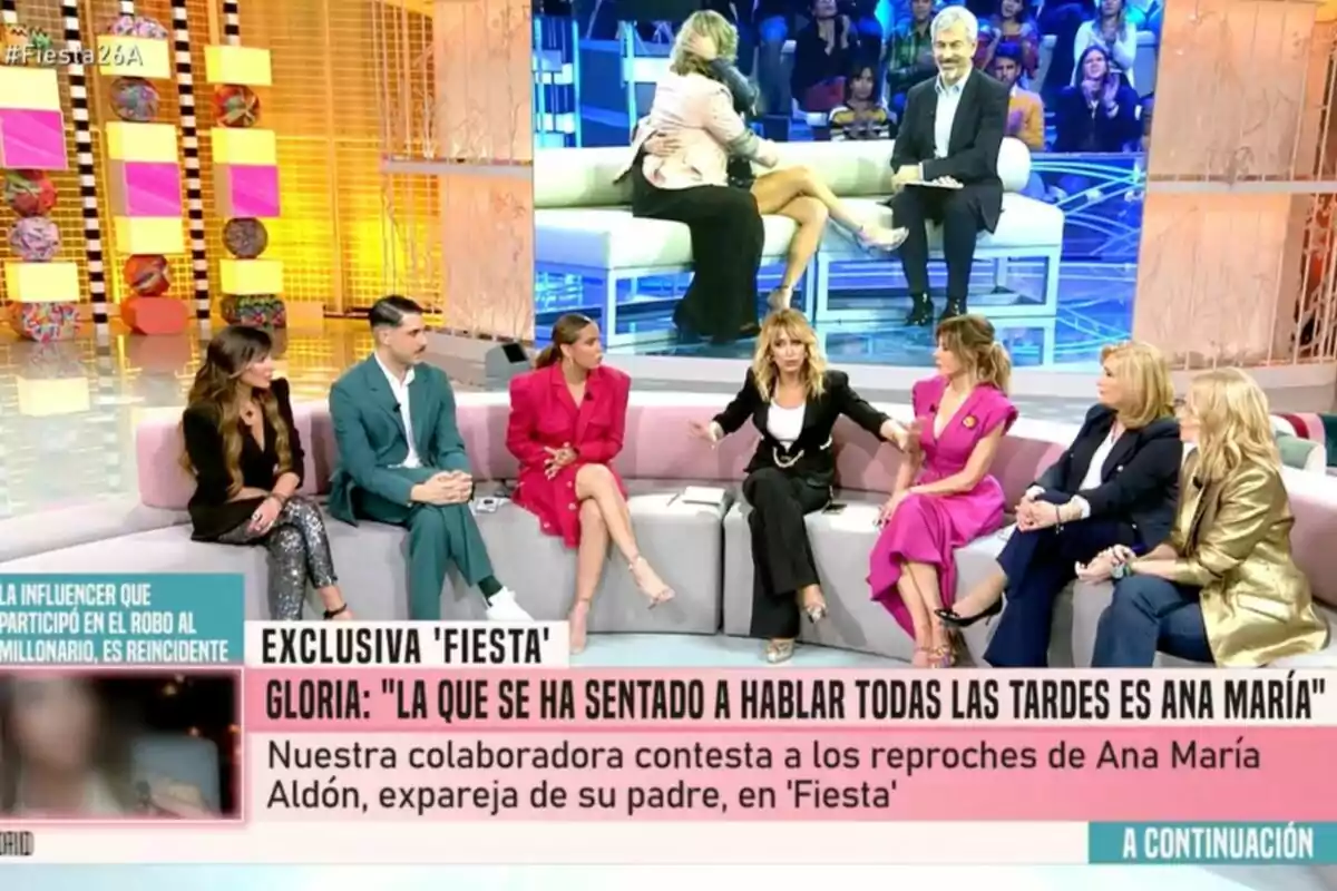 Un grupo de personas está sentado en un set de televisión, participando en un programa de entrevistas con una pantalla grande detrás que muestra una imagen relacionada con el tema discutido. Captura de 'Fiesta' Un grupo de personas está sentado en un set de televisión, participando en un programa de entrevistas con una pantalla grande detrás que muestra una imagen relacionada con el tema discutido. Captura de 'Fiesta'