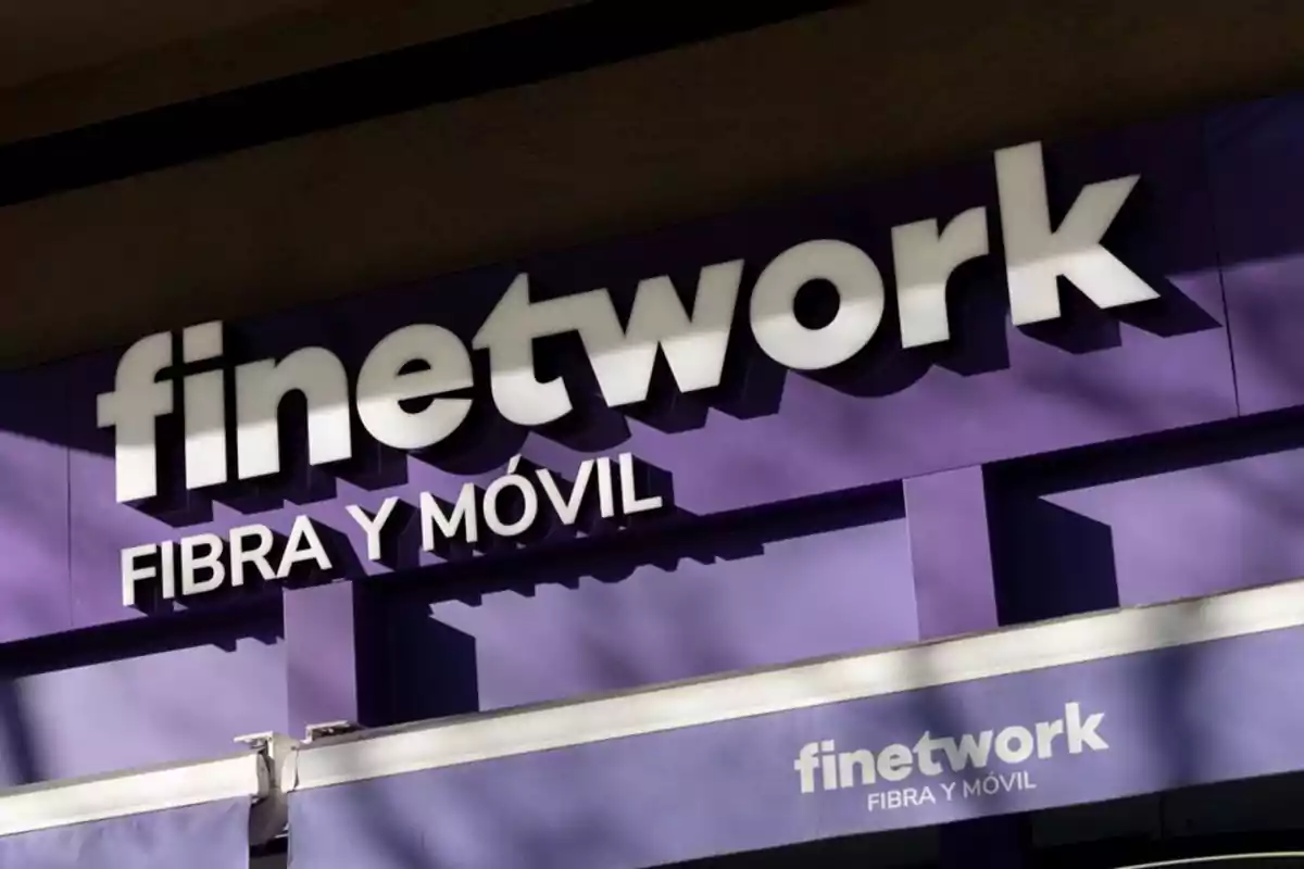 Un cartel de una tienda de telecomunicaciones con letras blancas sobre un fondo morado. Un cartel de una tienda de telecomunicaciones con letras blancas sobre un fondo morado.