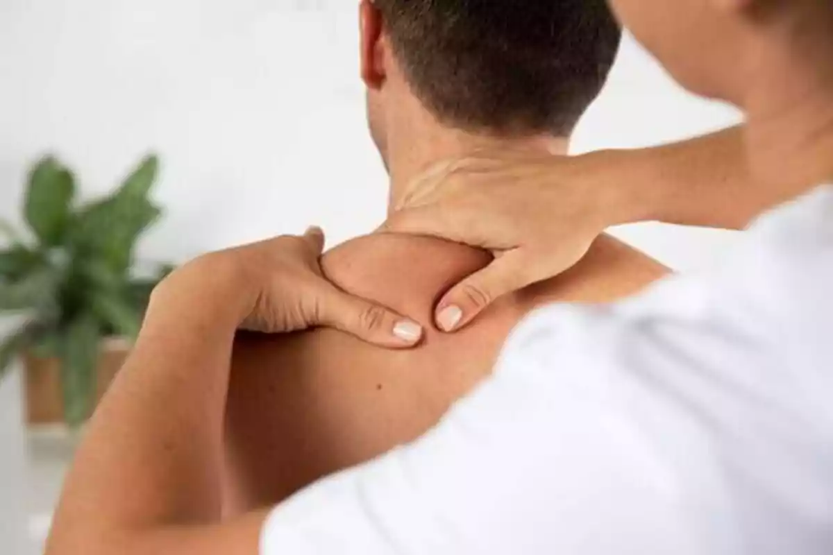 Persona recibiendo un masaje en el cuello y los hombros.