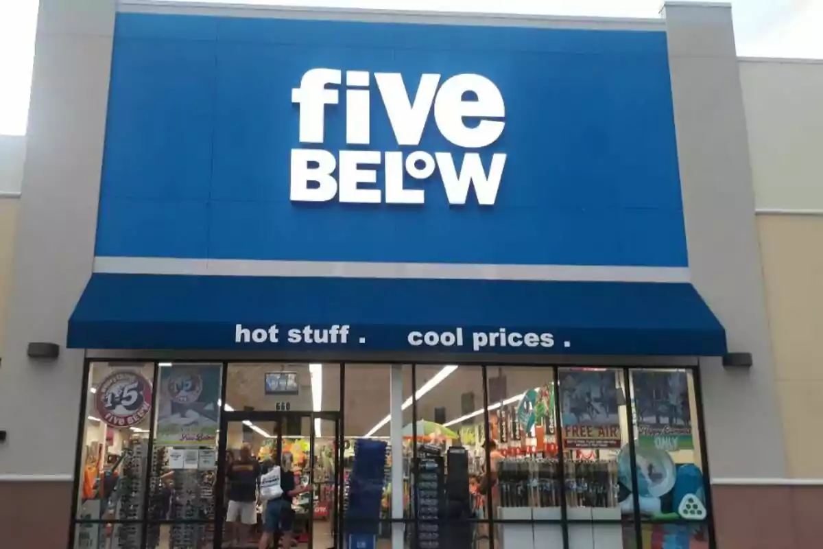 Facade of a Five Below store with a blue sign and people entering the establishment Facade of a Five Below store with a blue sign and people entering the establishment