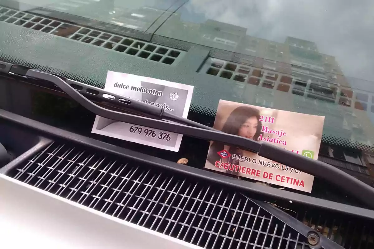 Dos folletos publicitarios colocados bajo el limpiaparabrisas de un coche. Dos folletos publicitarios colocados bajo el limpiaparabrisas de un coche.