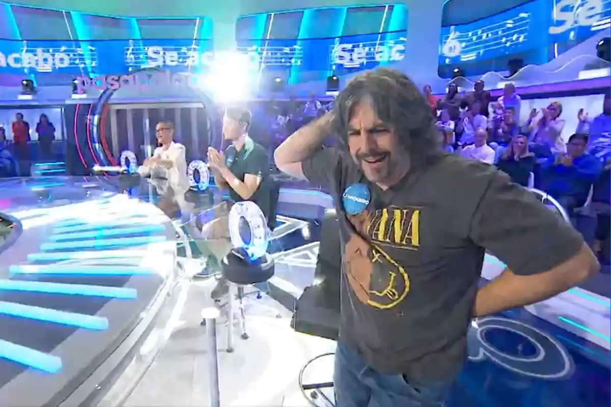 J. J. Vázquez con camiseta de Nirvana en 'Pasapalabra' con público y otros participantes al fondo J. J. Vázquez con camiseta de Nirvana en 'Pasapalabra' con público y otros participantes al fondo