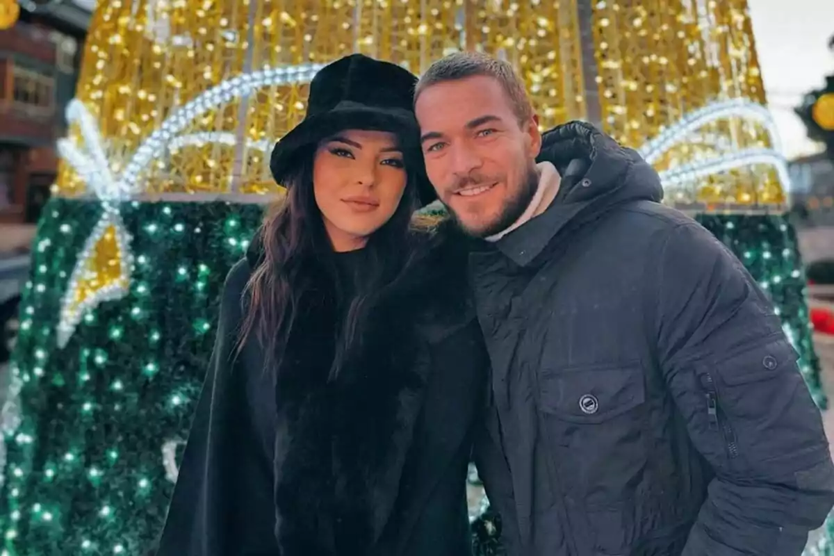 Foto de Marta Peñate y Tony Spina posando juntos frente a un árbol de luces de Navidad