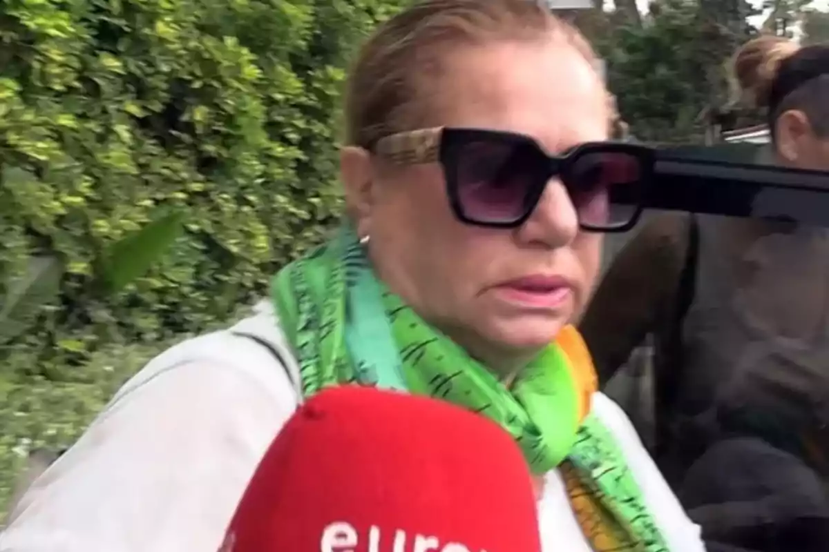 Mayte Zaldívar con gafas de sol, coleta y pañuelo verde es entrevistada por Europa Press en las puertas del hospital donde está ingresado Julián Muñoz