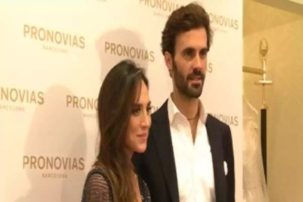 Pareja posando en un evento de Pronovias con fondo de logotipos de la marca. Pareja posando en un evento de Pronovias con fondo de logotipos de la marca.
