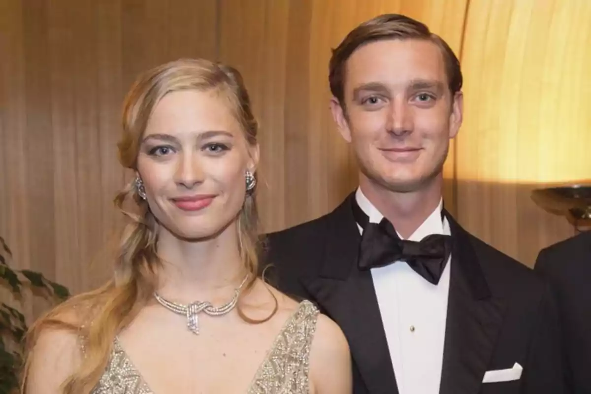 Una pareja elegantemente vestida en un evento formal con fondo de madera. Una pareja elegantemente vestida en un evento formal con fondo de madera.