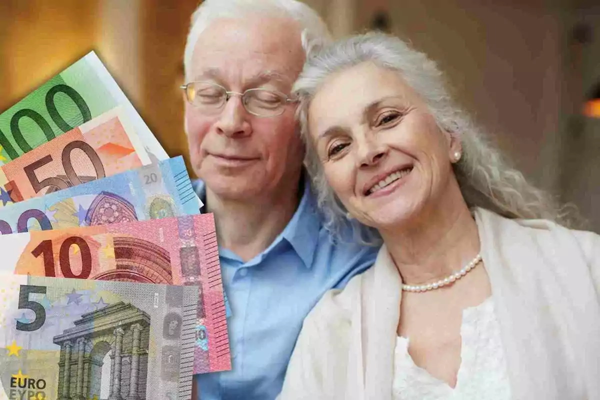 Una pareja de personas mayores sonríe mientras se muestra una variedad de billetes de euro en primer plano.