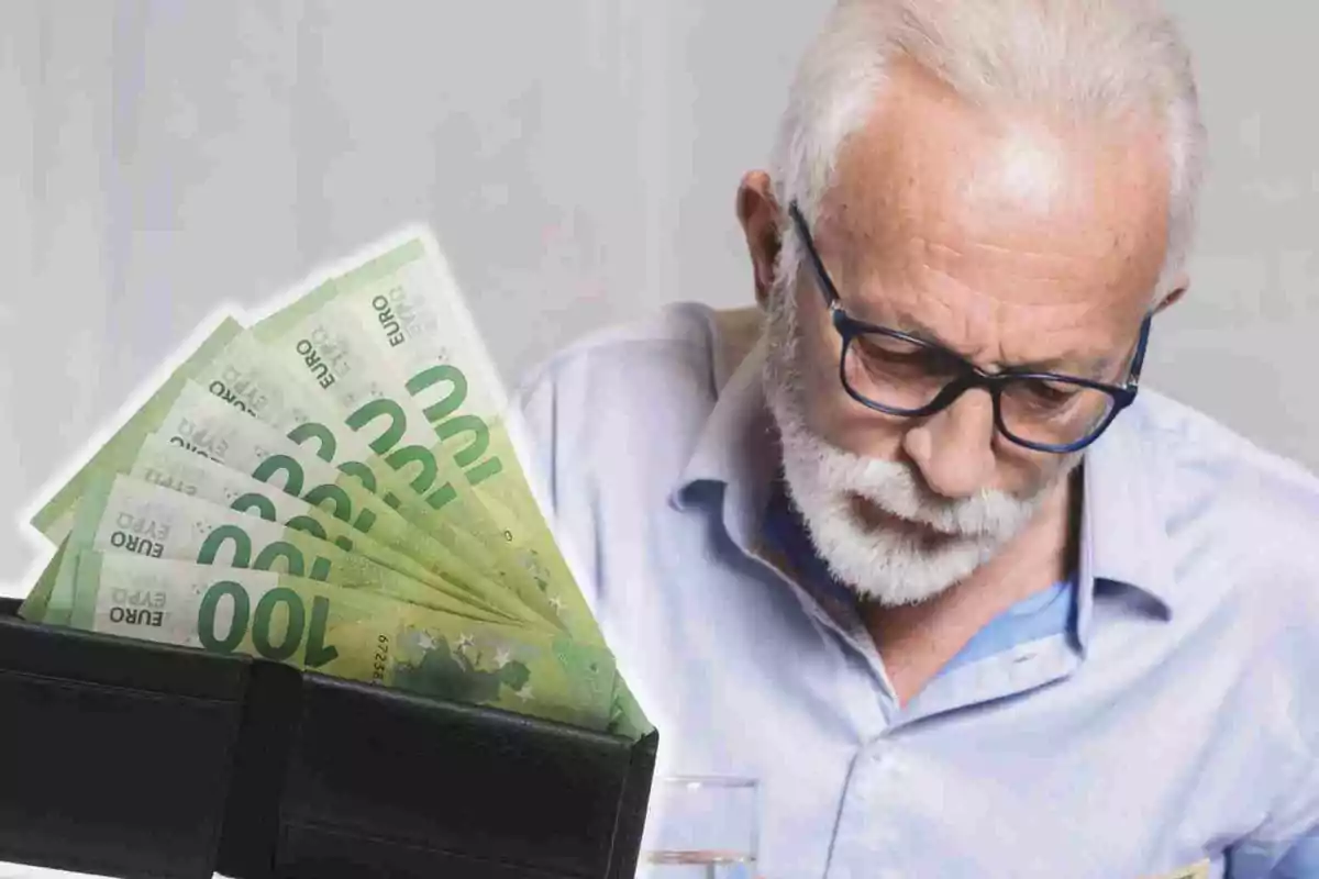 Hombre mayor con gafas y barba blanca mirando hacia abajo junto a una billetera abierta con billetes de 100 euros.