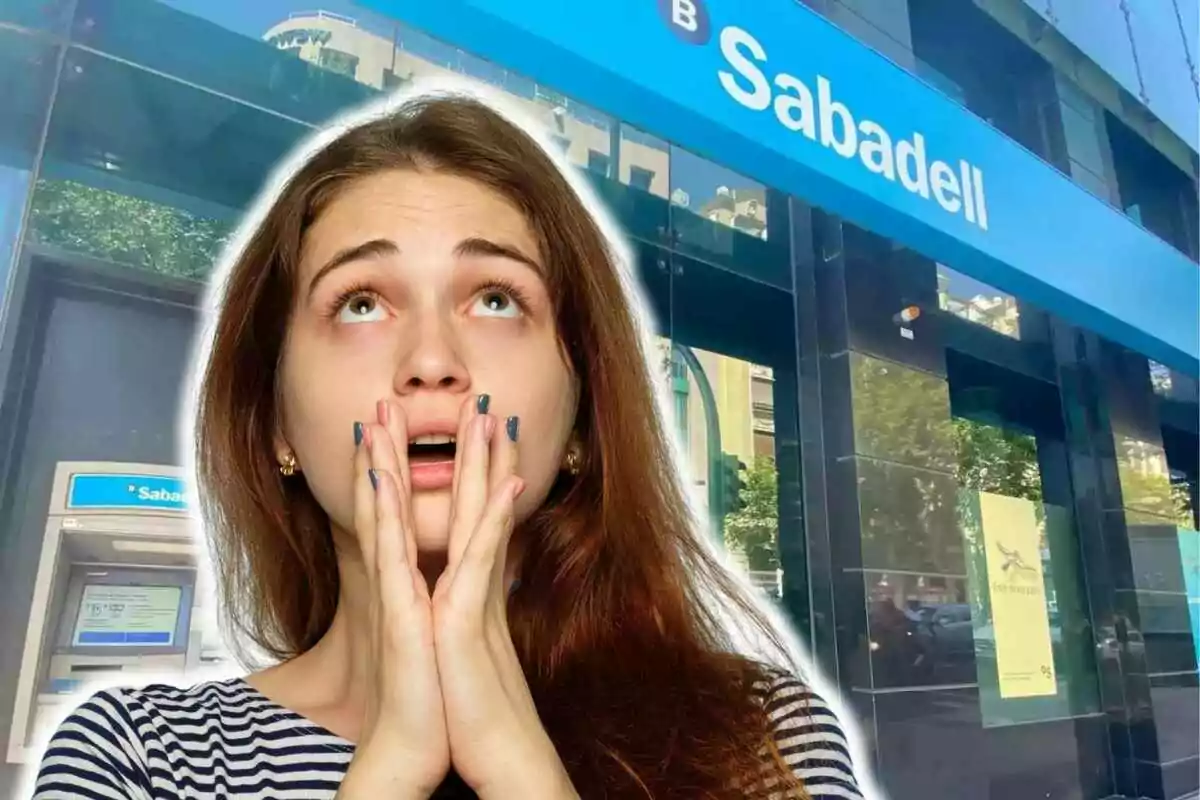 Una mujer con expresión de sorpresa o preocupación frente a una sucursal del banco Sabadell.