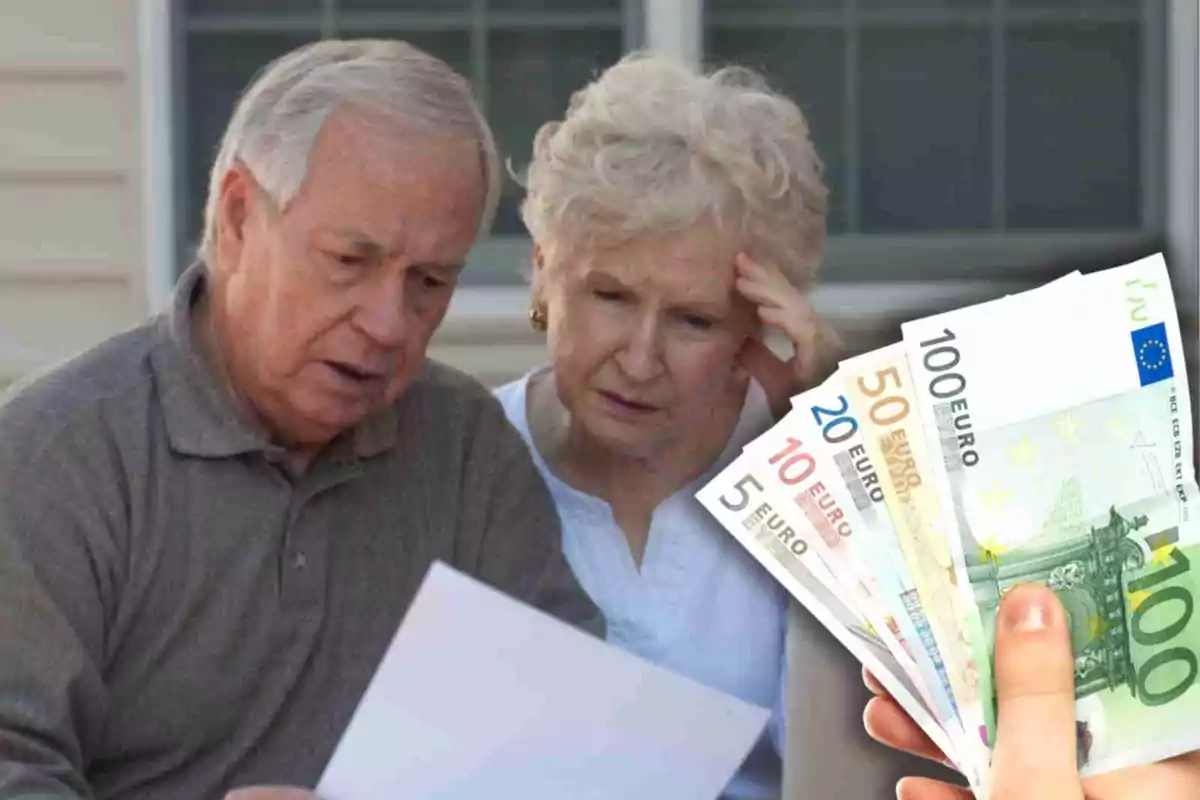 Una pareja de personas mayores mirando preocupados un documento mientras una mano sostiene billetes de euro.