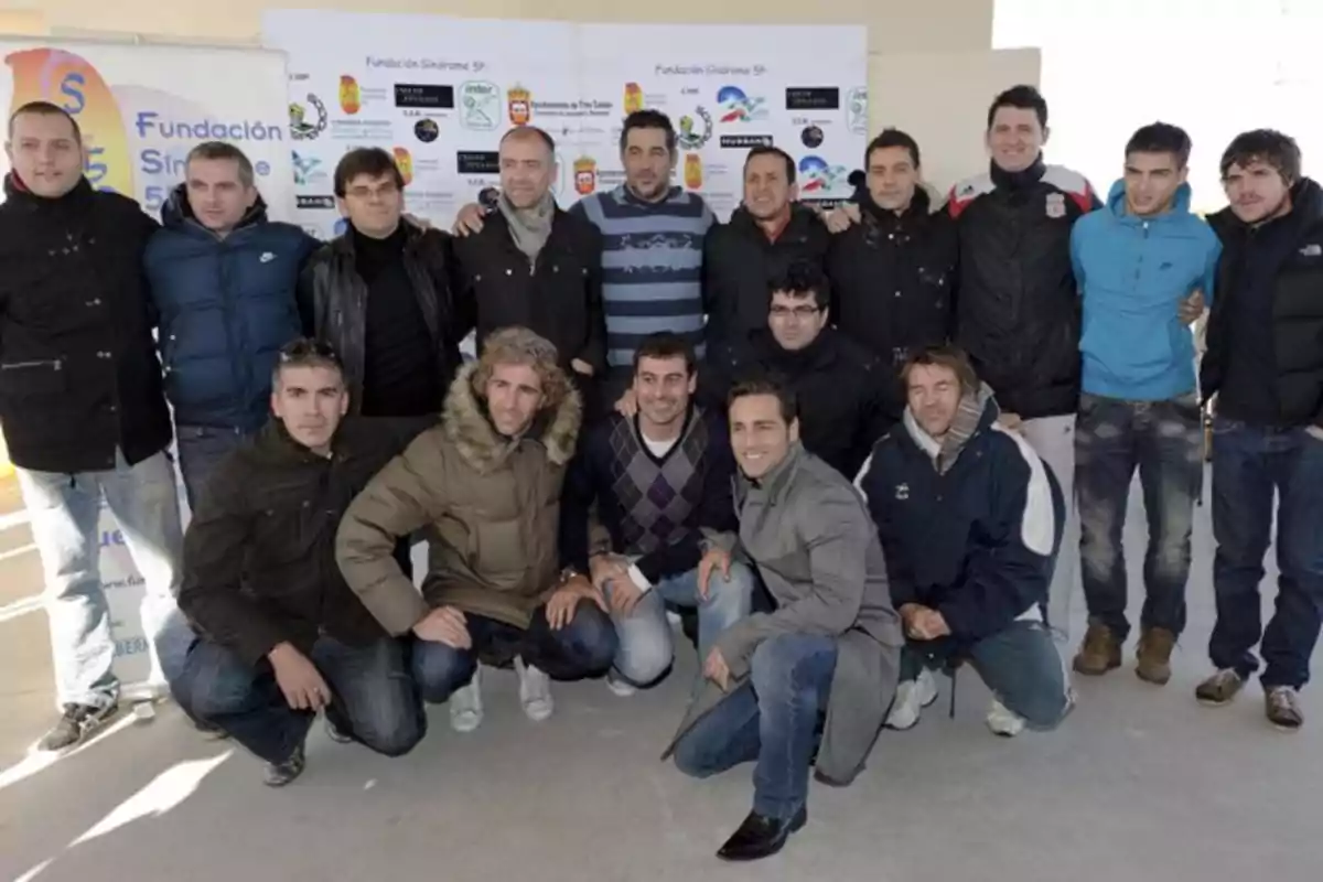 Un grupo de personas posando juntas frente a un fondo con logotipos y carteles de la Fundación Síndrome 5p. Un grupo de personas posando juntas frente a un fondo con logotipos y carteles de la Fundación Síndrome 5p.
