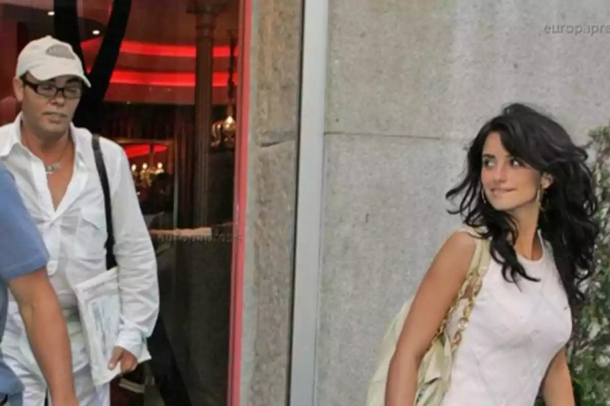 Una mujer con vestido blanco y bolso dorado camina por la calle mientras un hombre con camisa blanca y gorra la sigue. Una mujer con vestido blanco y bolso dorado camina por la calle mientras un hombre con camisa blanca y gorra la sigue.