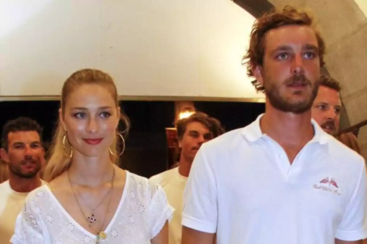 Un grupo de personas en un evento con una mujer y un hombre al frente ambos con ropa casual. Un grupo de personas en un evento con una mujer y un hombre al frente ambos con ropa casual.