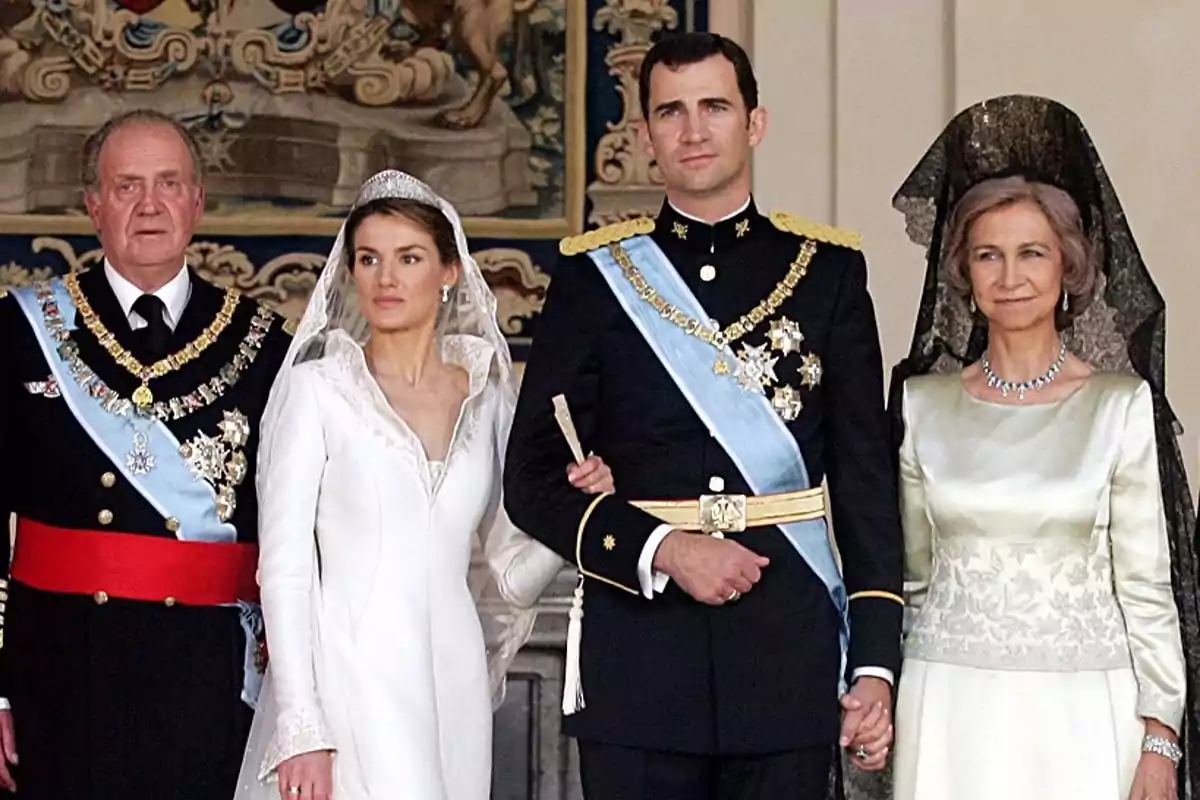 Cuatro personas posan elegantemente vestidas en una ceremonia de boda, dos de ellas con uniforme militar y las otras dos con vestidos formales, una de las mujeres lleva un vestido de novia blanco y velo Cuatro personas posan elegantemente vestidas en una ceremonia de boda, dos de ellas con uniforme militar y las otras dos con vestidos formales, una de las mujeres lleva un vestido de novia blanco y velo